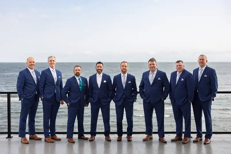 Groomsmen portrait overlooking the ocean at beach wedding