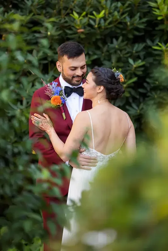 Bride and groom embracing in garden at Saint Clements Castle