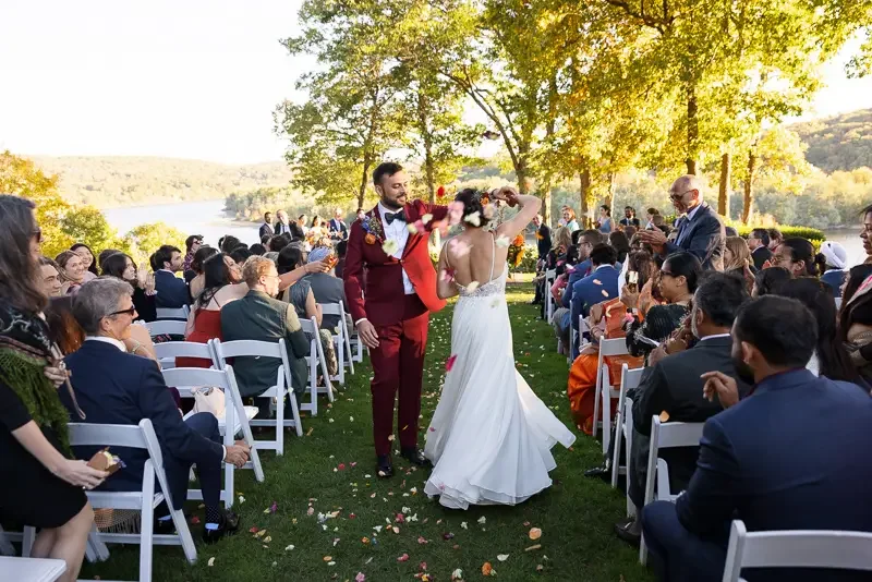 Newlyweds walking back down the aisle after outdoor fall wedding ceremony