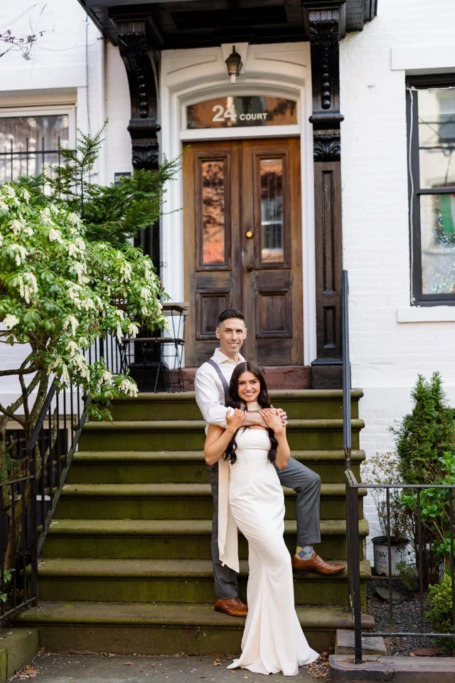 Engaged couple posing on brownstone steps in New Haven