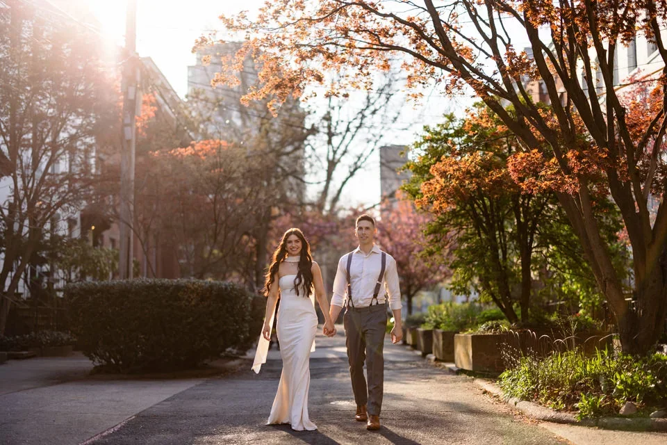 Engaged couple walking through Wooster Square garden path at golden hour