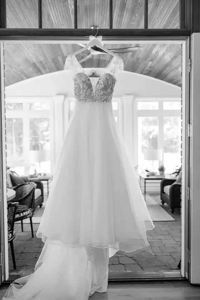 wedding-dress-hanging-by-window-black-and-white.webp