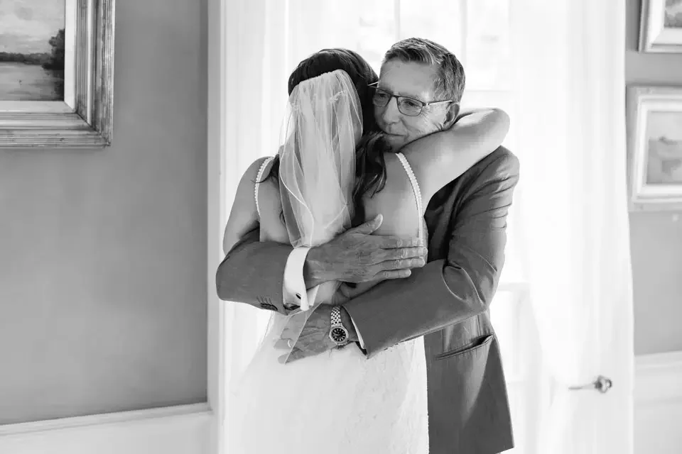 emotional-bride-hug-with-father-black-and-white.webp