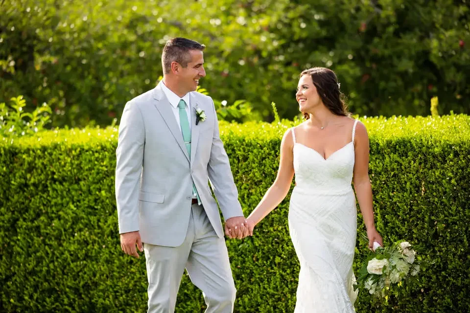 bride-and-groom-walking-hand-in-hand-smith-farm-gardens.webp