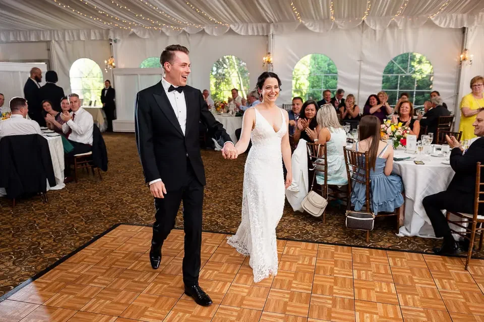 bride-and-groom-grand-entrance-tent-reception.webp