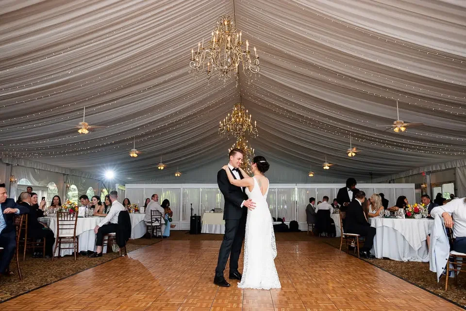 first-dance-under-draped-tent-wedding-reception.webp