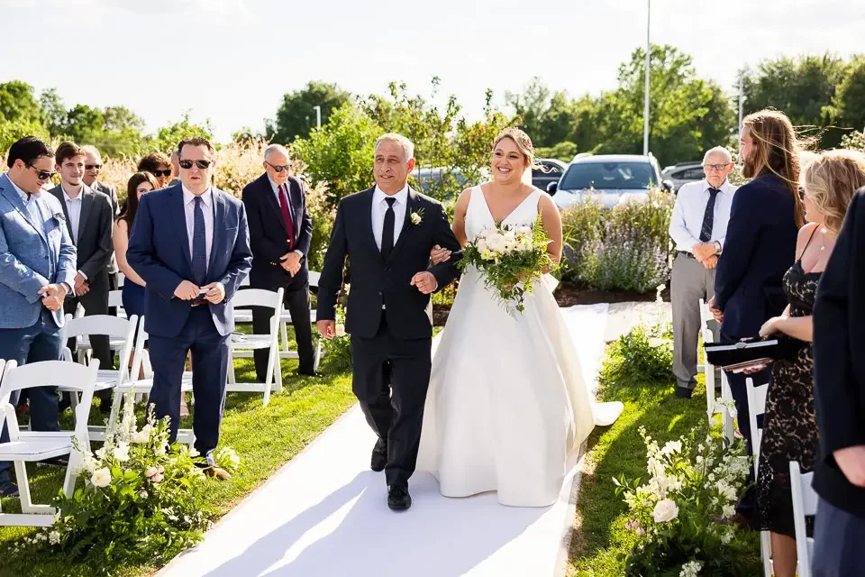Bride Walks Down the Aisle During Outdoor Wedding Ceremony