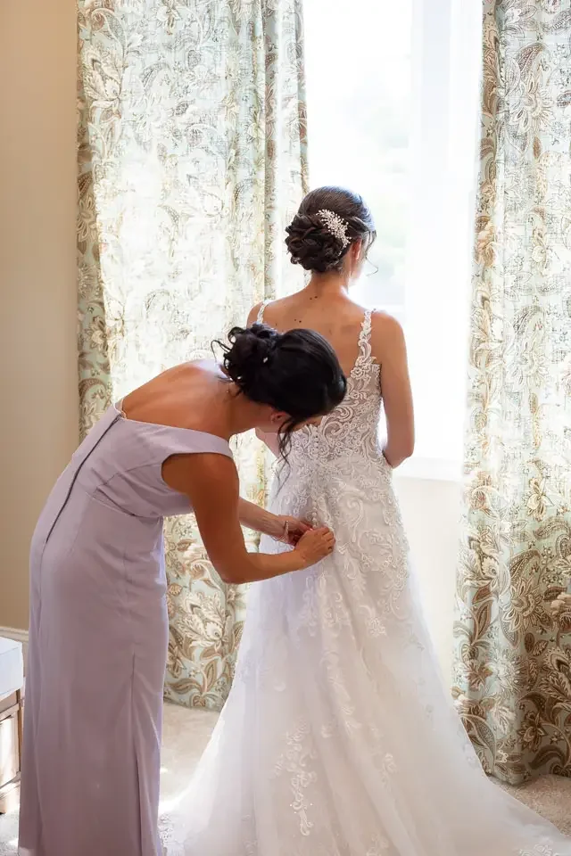 Bridesmaid Buttoning Wedding Dress
