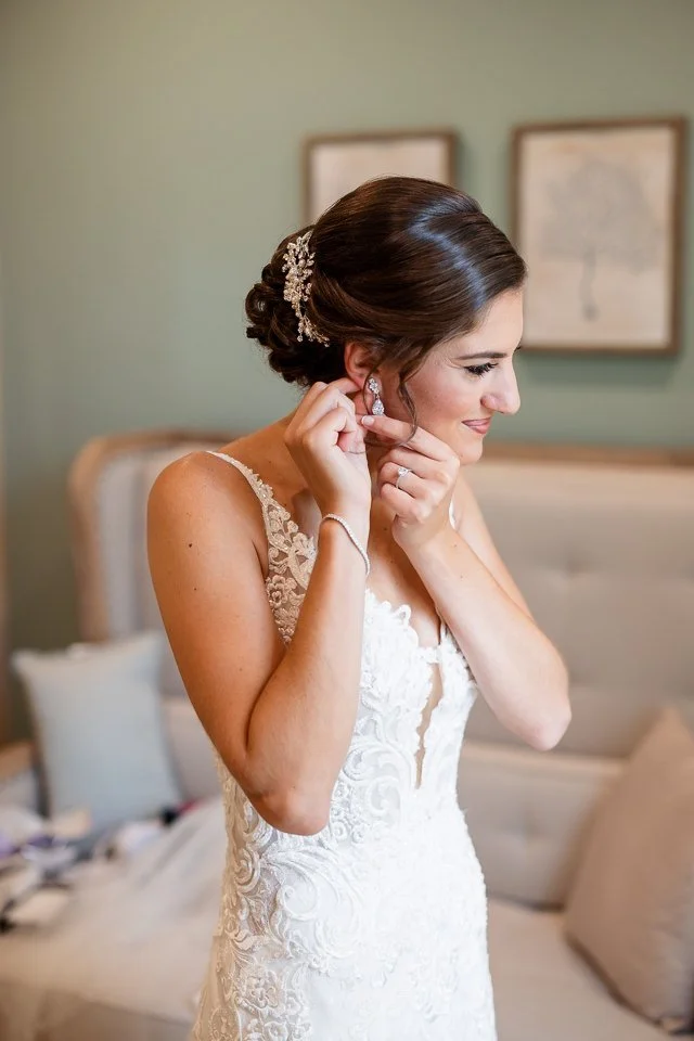 bride-white-lace-dress-fastening-earring.jpg