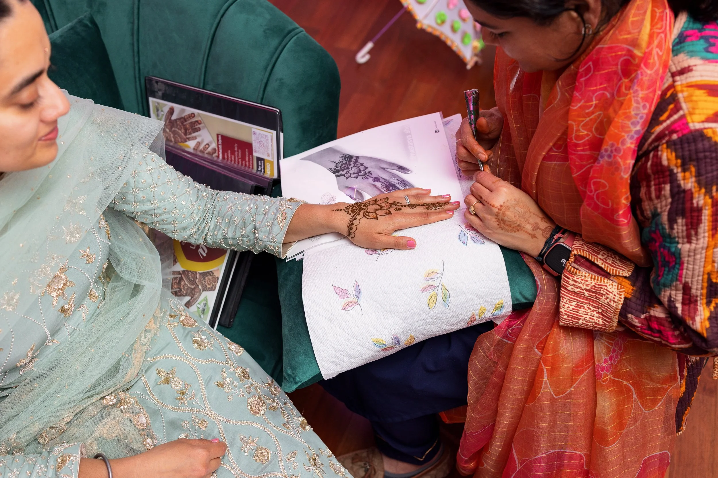 receives-henna-hand-seated-green-couch.jpg