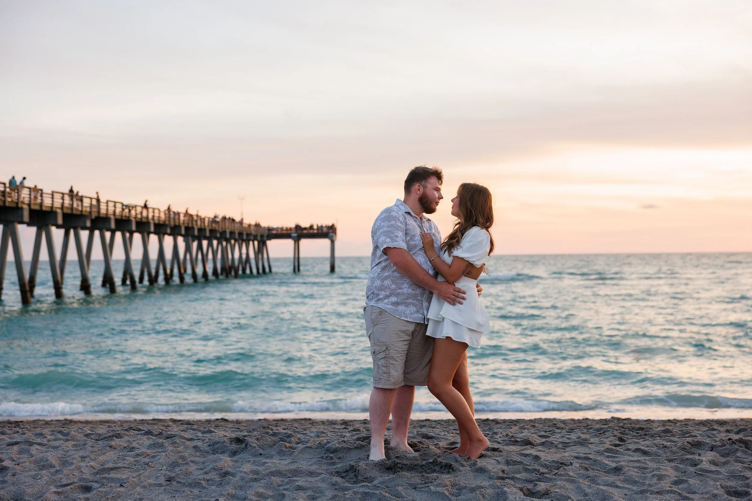 06-couple-embracing-beach-sunset-pier-background.jpg