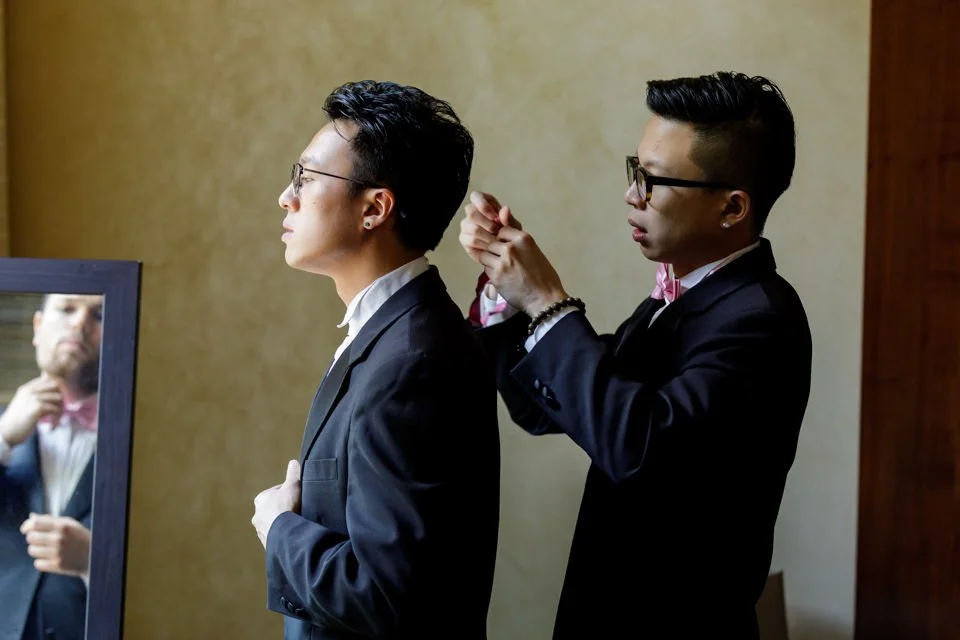 04-dark-suits-glasses-adjusting-pink-bow.jpg