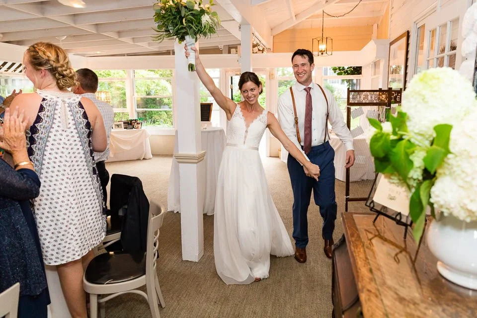 27-couple-walking-hand-through-indoor-reception.jpg