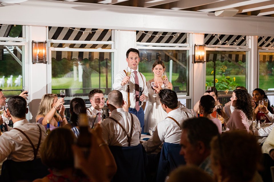 30-bride-groom-raising-glasses-surrounded-guests.jpg