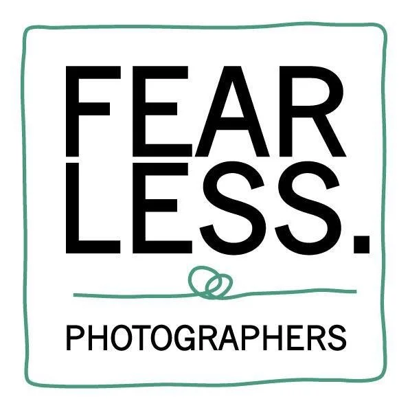 A white square with the words 'FEAR LESS' in large, bold black letters, and 'PHOTOGRAPHERS' in smaller black letters below. The square has a simple green hand-drawn border and a small green line under the word 'LESS' with a looped circle in the middle.
