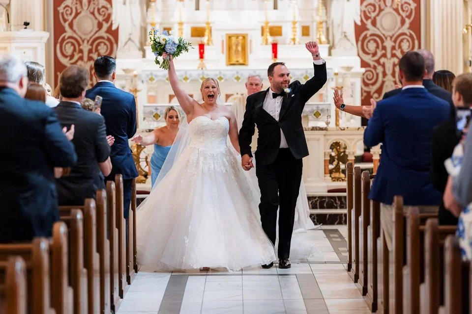 Bride and groom celebrating as they walk back down the aisle after their wedding ceremony, captured in a candid and joyful moment.