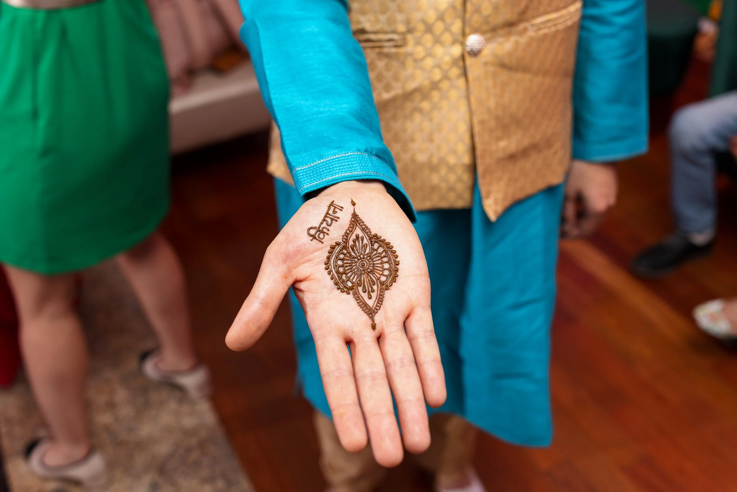 A person shows a hand with intricate henna design.
