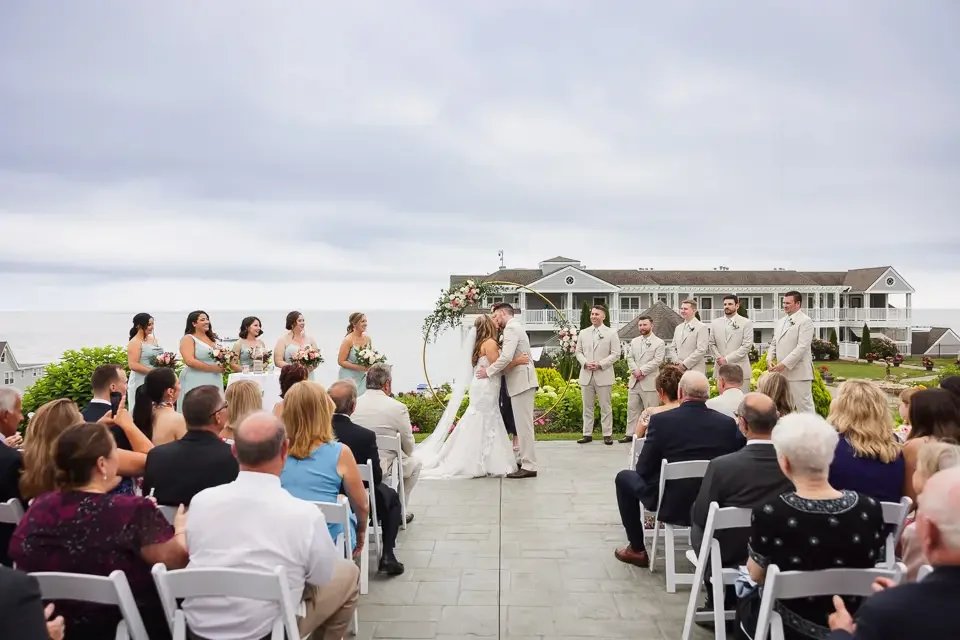 Newlyweds celebrating the conclusion of their wedding ceremony as guests applaud and share in the joy, creating a meaningful and connected experience.
