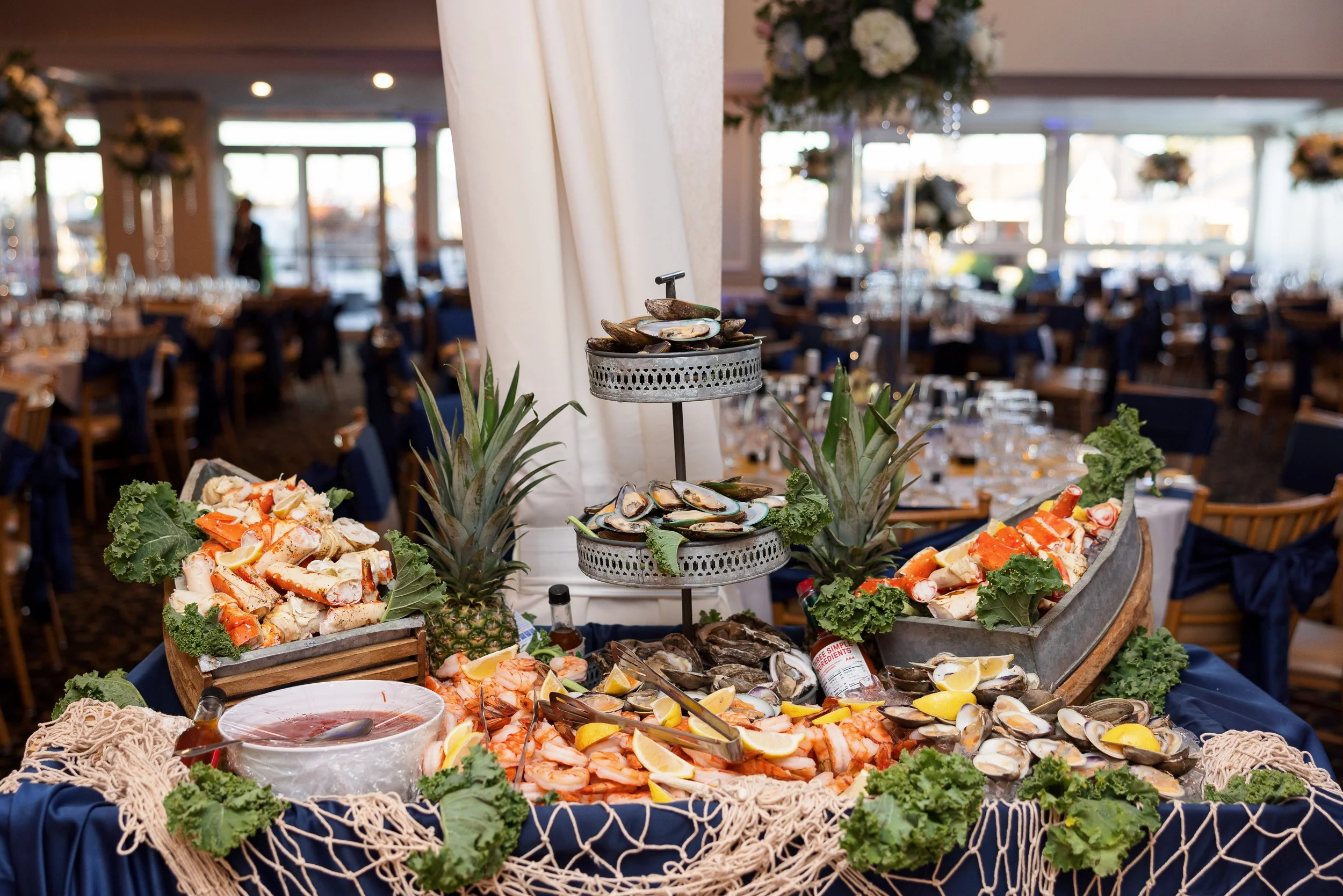 A seafood display of crab legs, shrimp and oysters on a table at a corporate event.