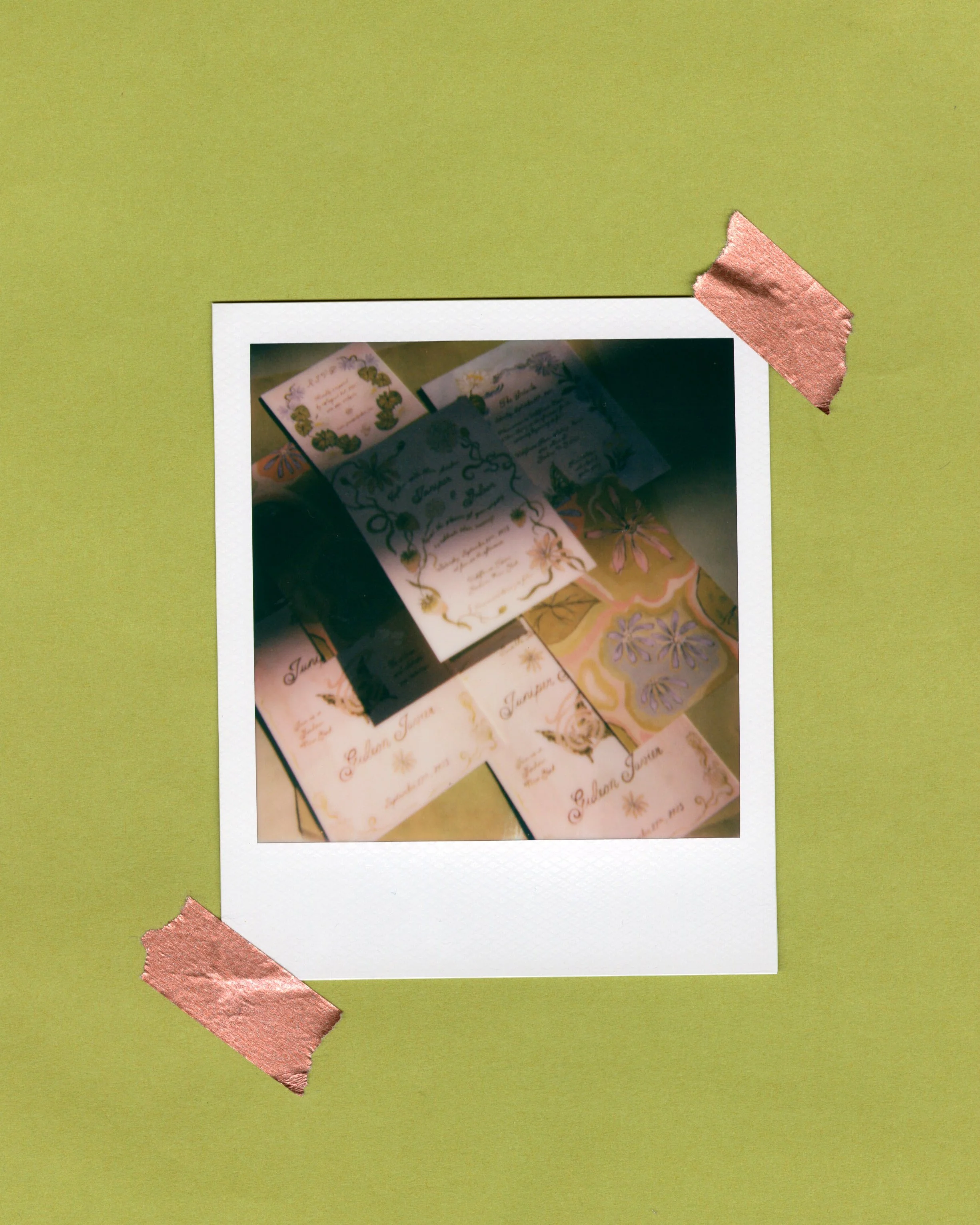 Polaroid picture with handwritten and decorated notes or invitations taped onto a light green background.