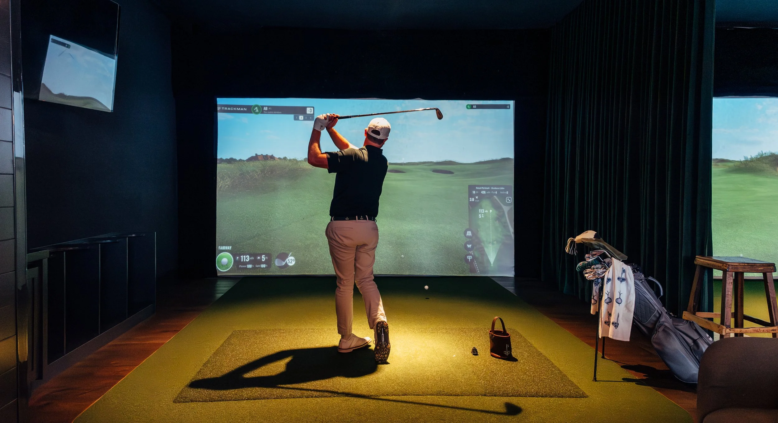 Intown Golf Club member swinging in golf simulator bay