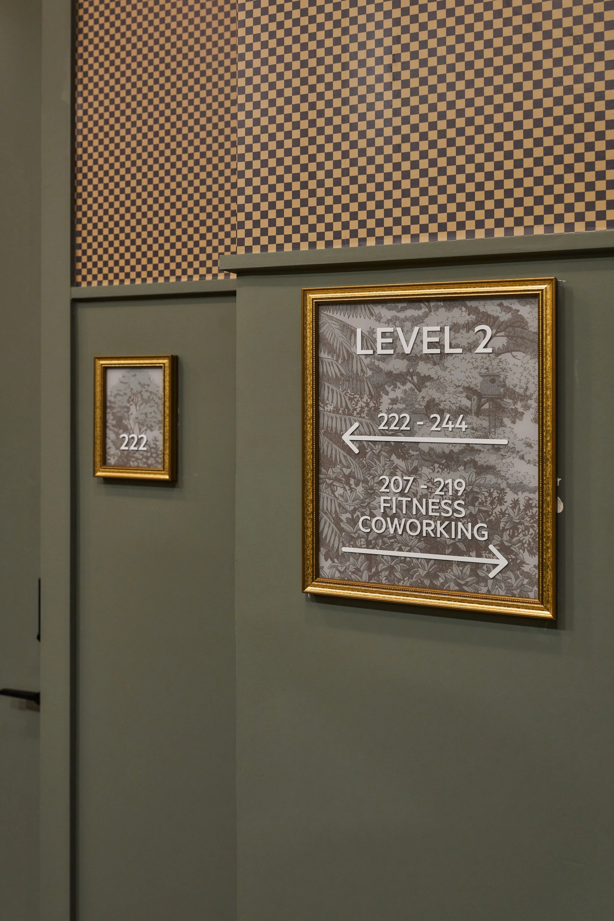 Sign indicating directions: arrow pointing left for rooms 222-244 and arrow pointing right for fitness and coworking on Level 2.