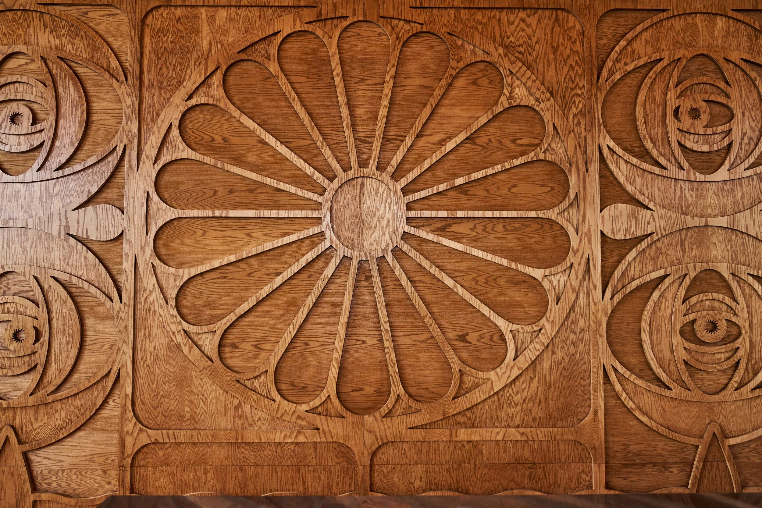 Intricate wooden wall panel with floral and swirling carved patterns