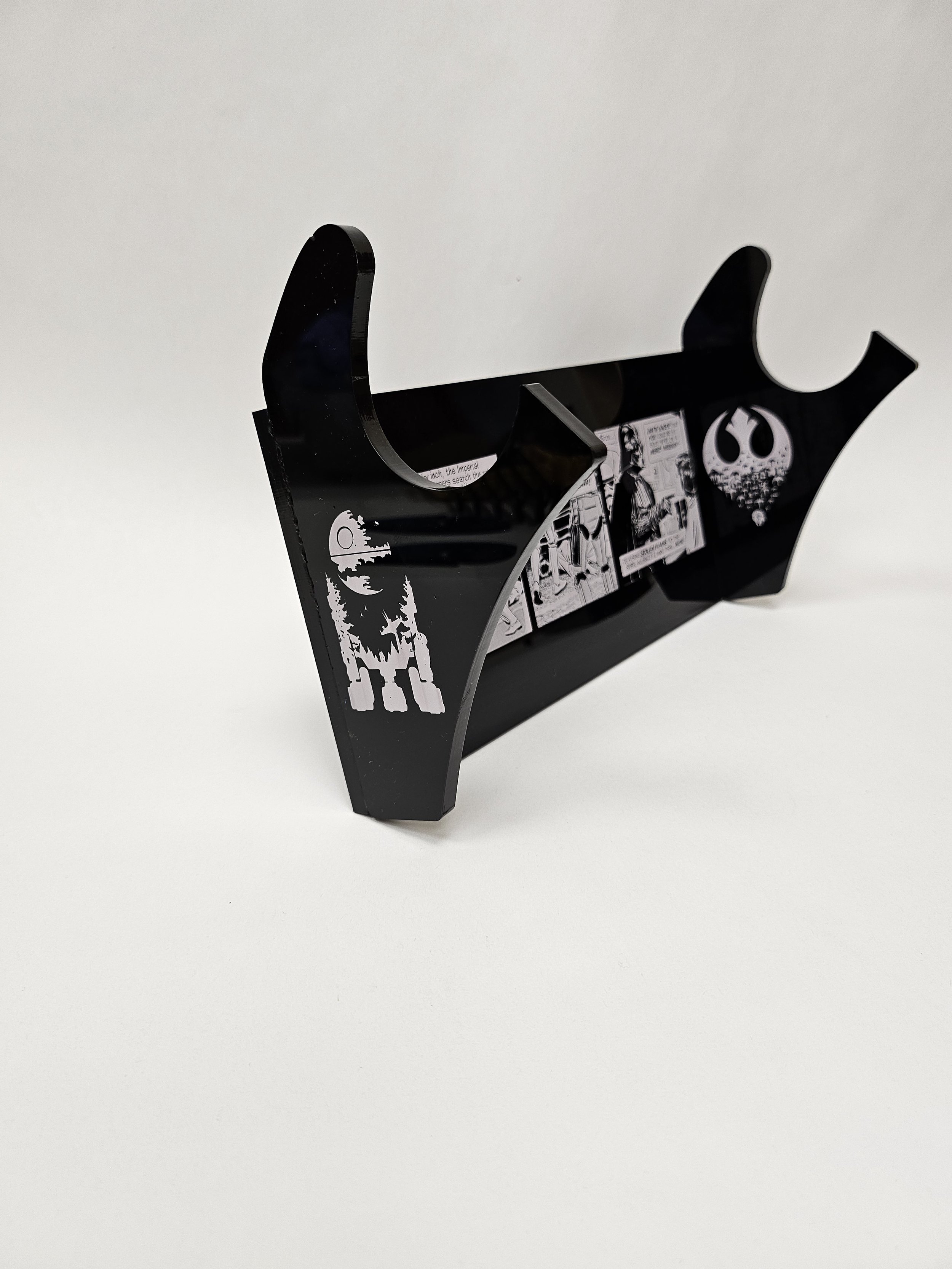 Left side view of black acrylic light saber mount with images of R2D2 and the Rebel Alliance logo with a comic strip of Darth Vader.