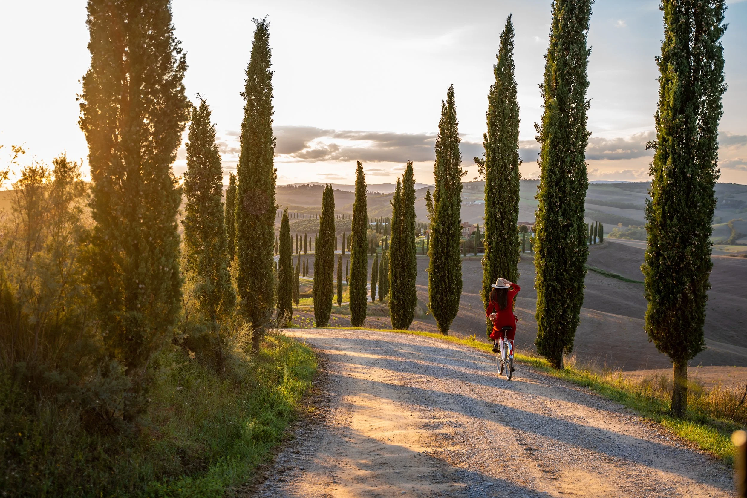 woman riding bike through tuscany village