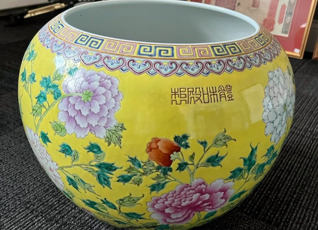 Yellow decorative ceramic bowl with floral pattern and Chinese characters.