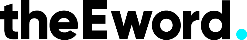 Two people sitting on a bench near a white vehicle, with trees and a sidewalk in the background.