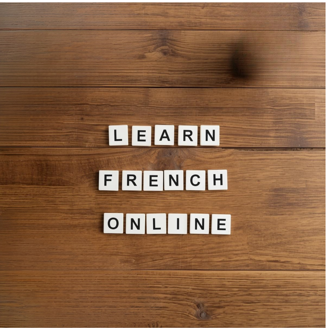 White letter tiles on a wooden surface spell out 'LEARN FRENCH ONLINE' in three rows.