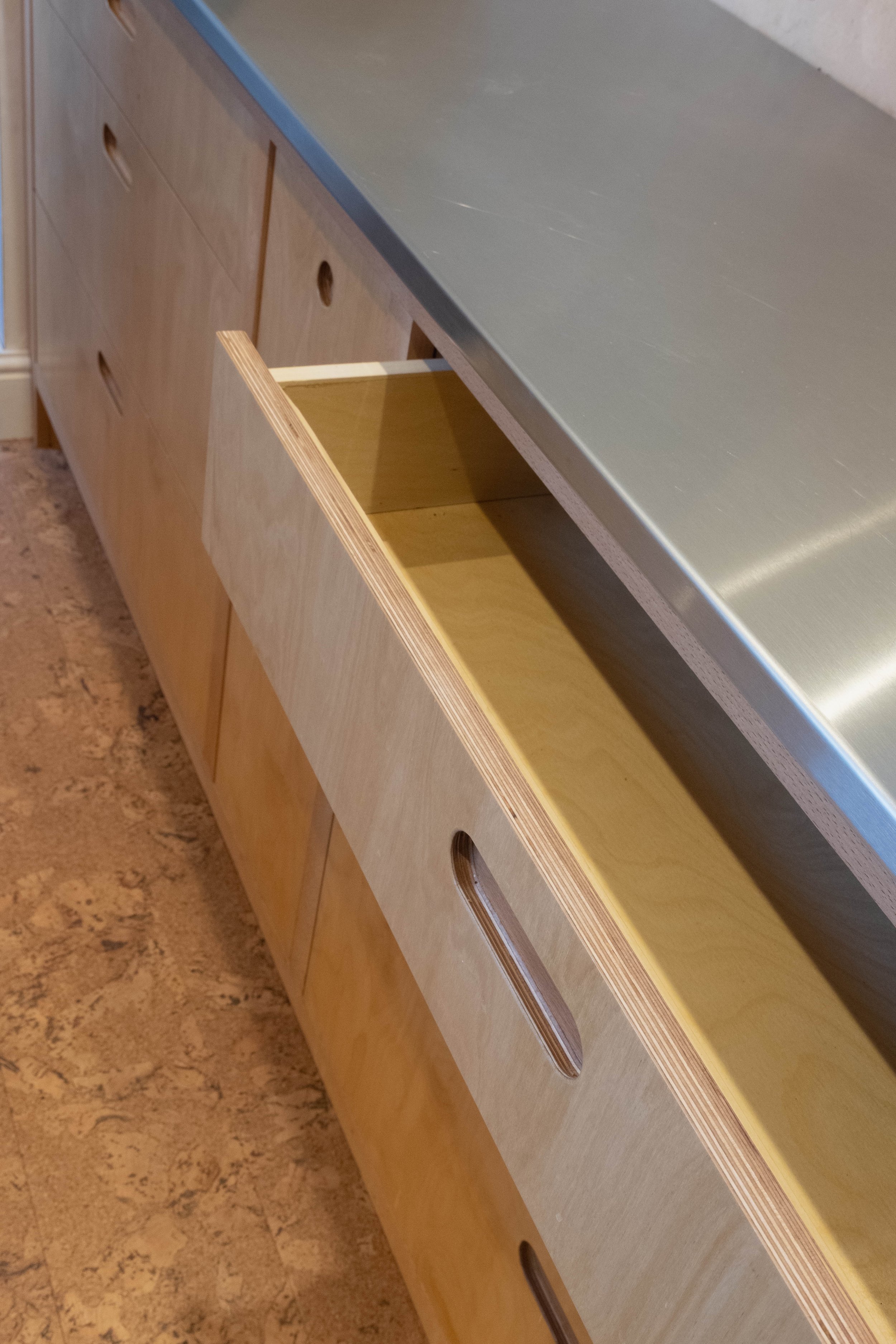 Open drawer in wooden cabinet showing interior.