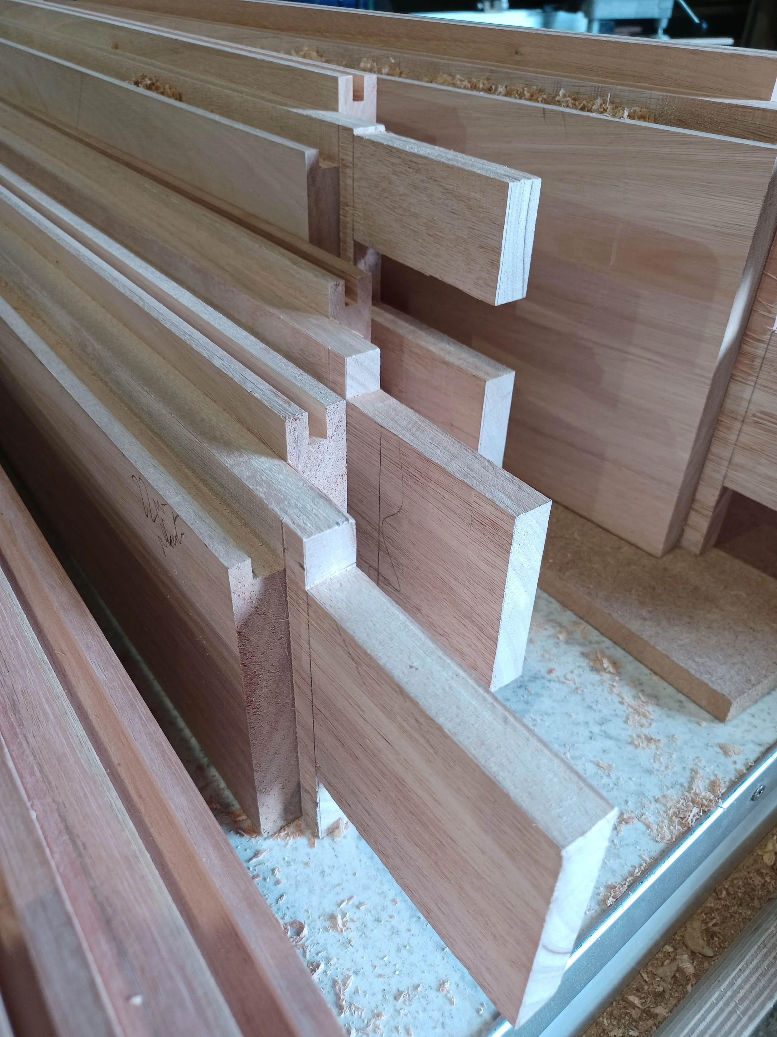 Stacked pieces of wood or plywood sheets in a workshop.