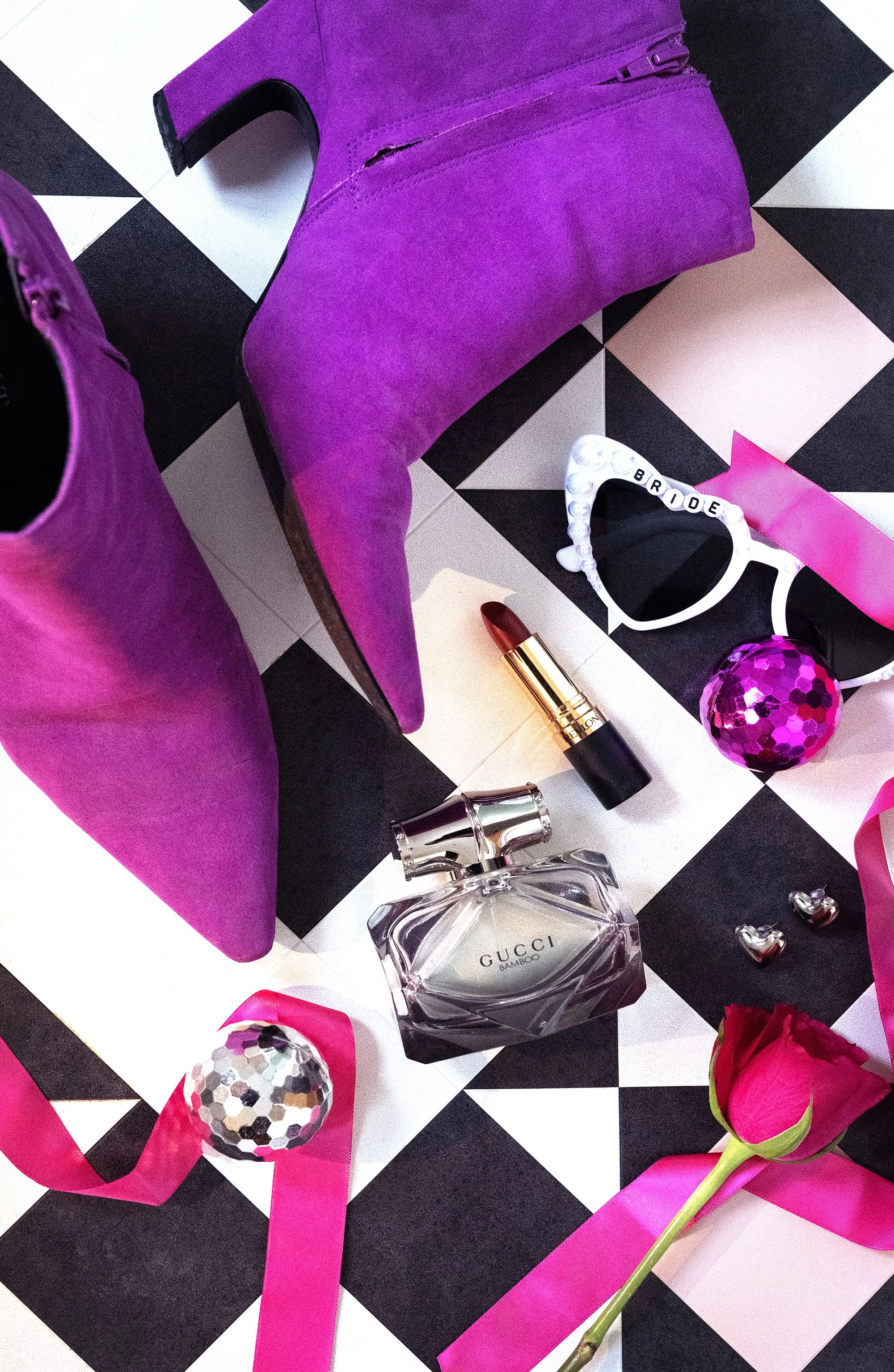 Bright pink bridal boots photographed alongside colourful wedding accessories including disco balls.