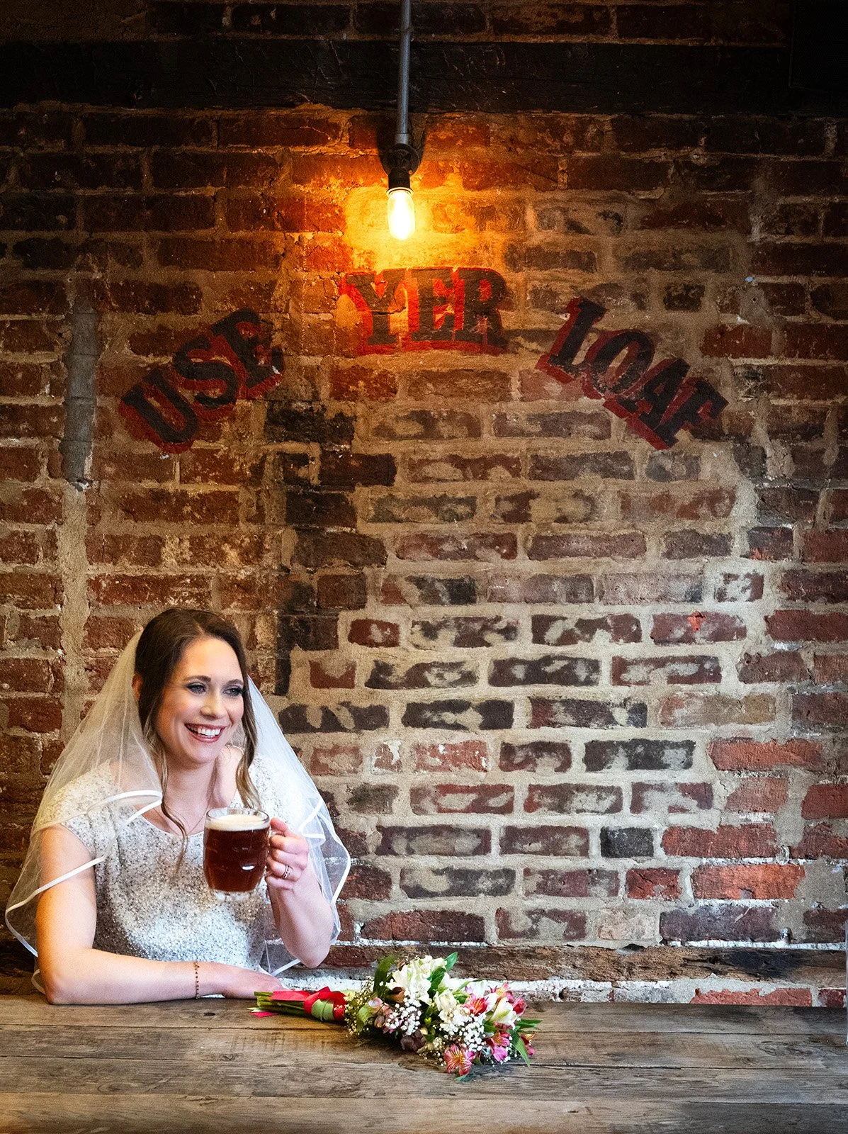 Bride enjoying a drink in a rustic pub during relaxed alternative wedding photography.
