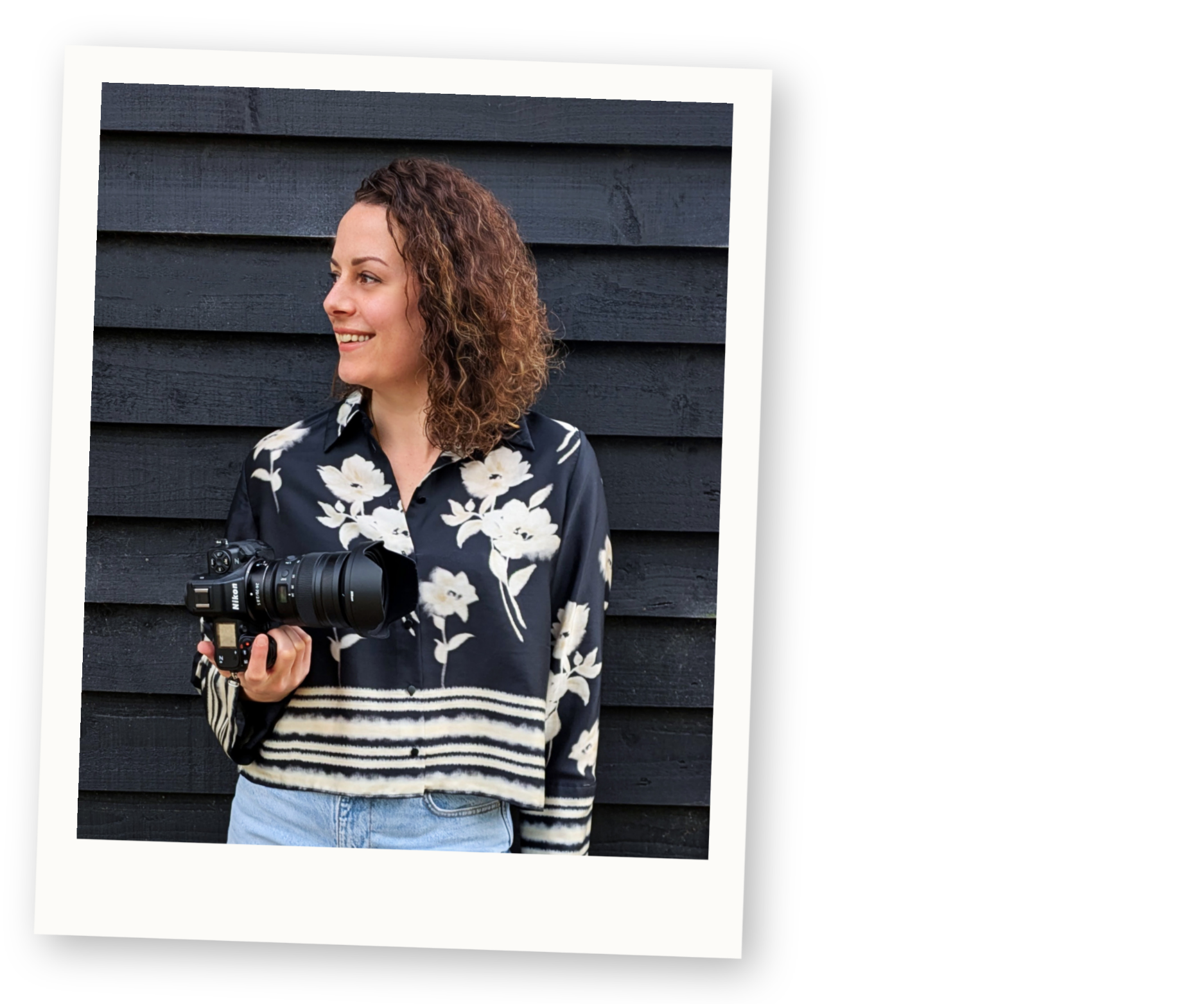 Steph, the photographer behind Kiss Photo, standing with her Nikon camera after photographing a colourful alternative wedding.