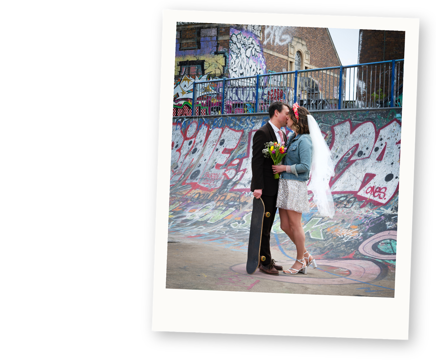 Couple kissing at an urban graffiti skatepark during an alternative wedding portrait session.