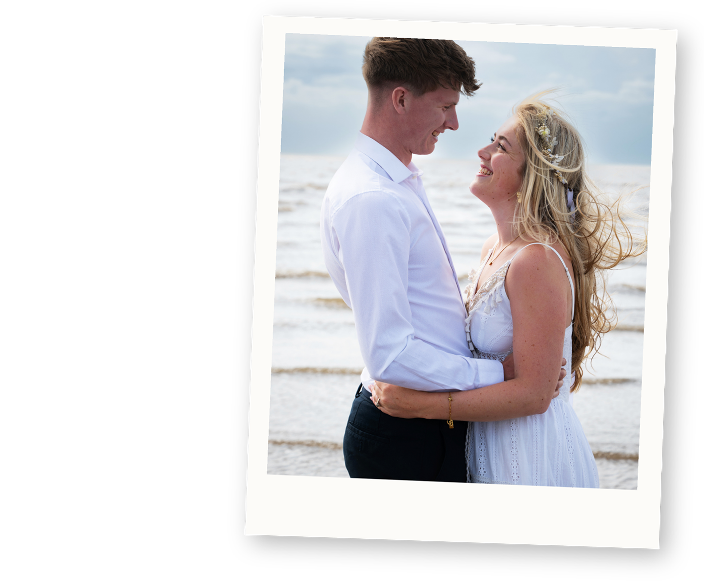 Relaxed couple smiling together on the beach after their wedding ceremony.