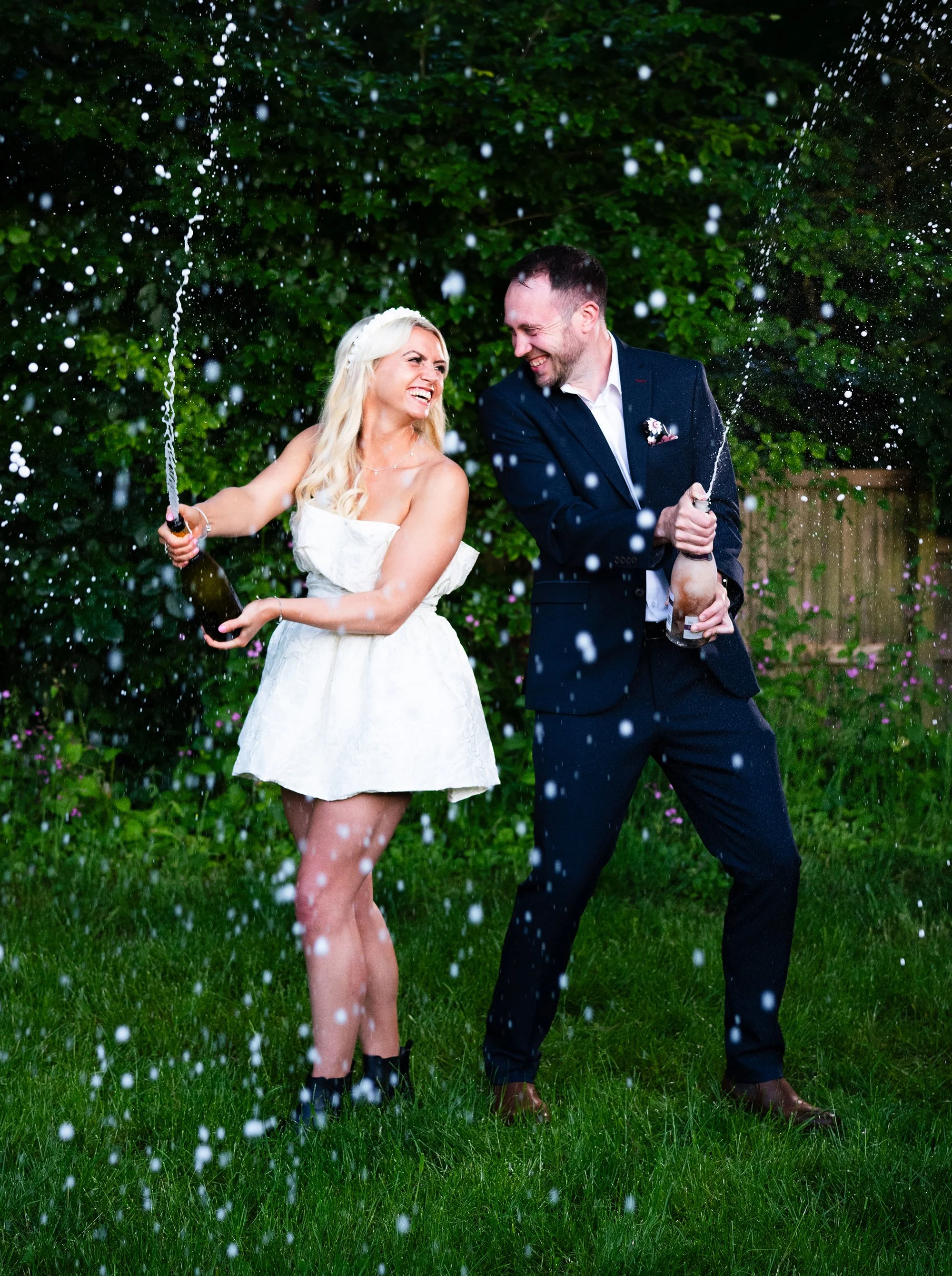 Bride and groom spraying champagne during their wedding celebrations.