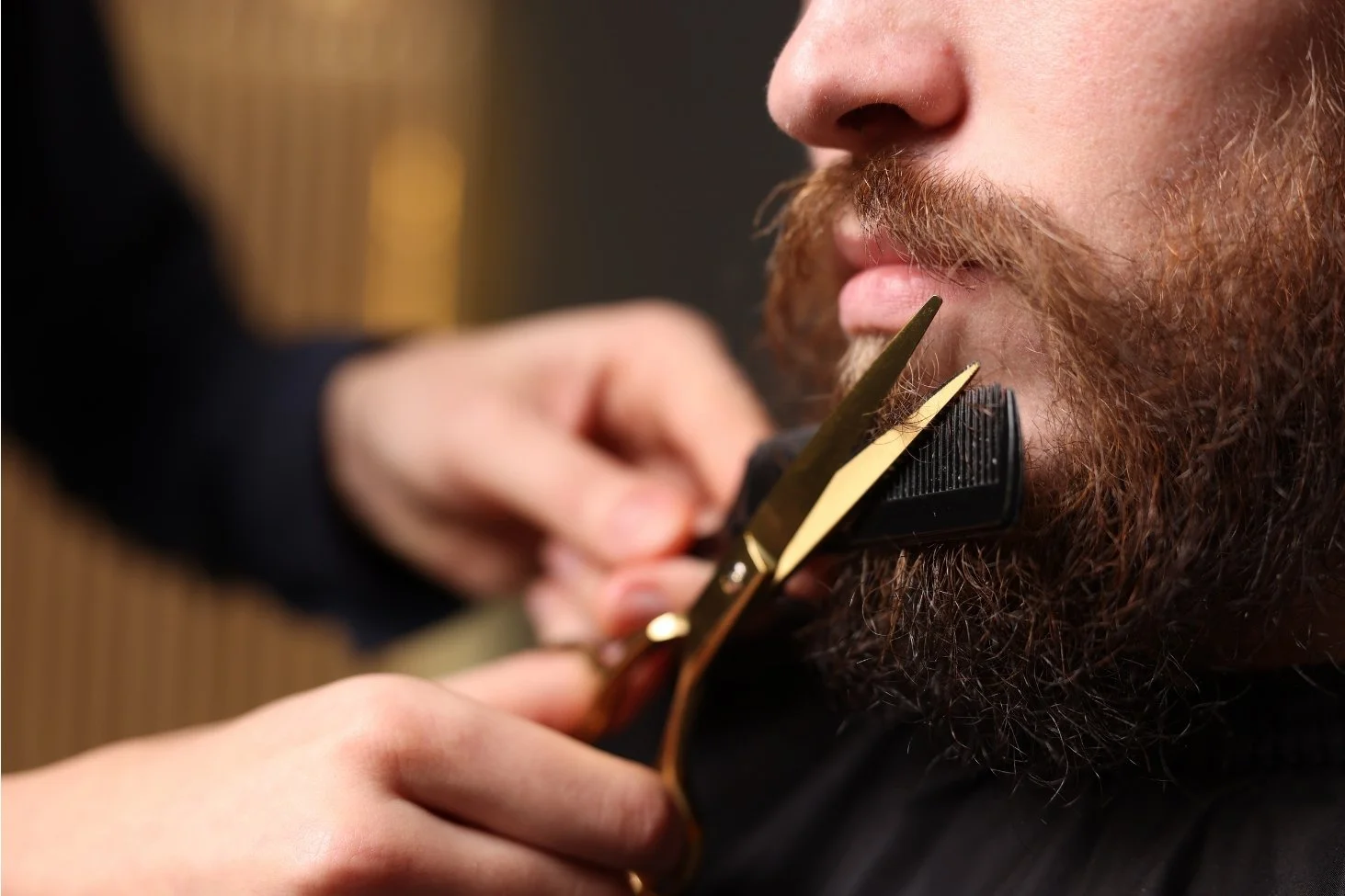 Stylist trimming a client's beard with scissors and comb at Willow's Cove Salon
