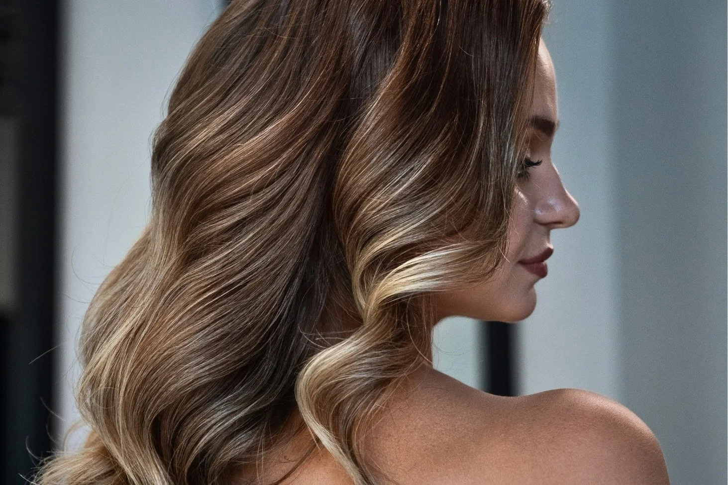 Woman with smooth, glossy, frizz-free hair after a Magic Sleek smoothing treatment at Willow's Cove Salon