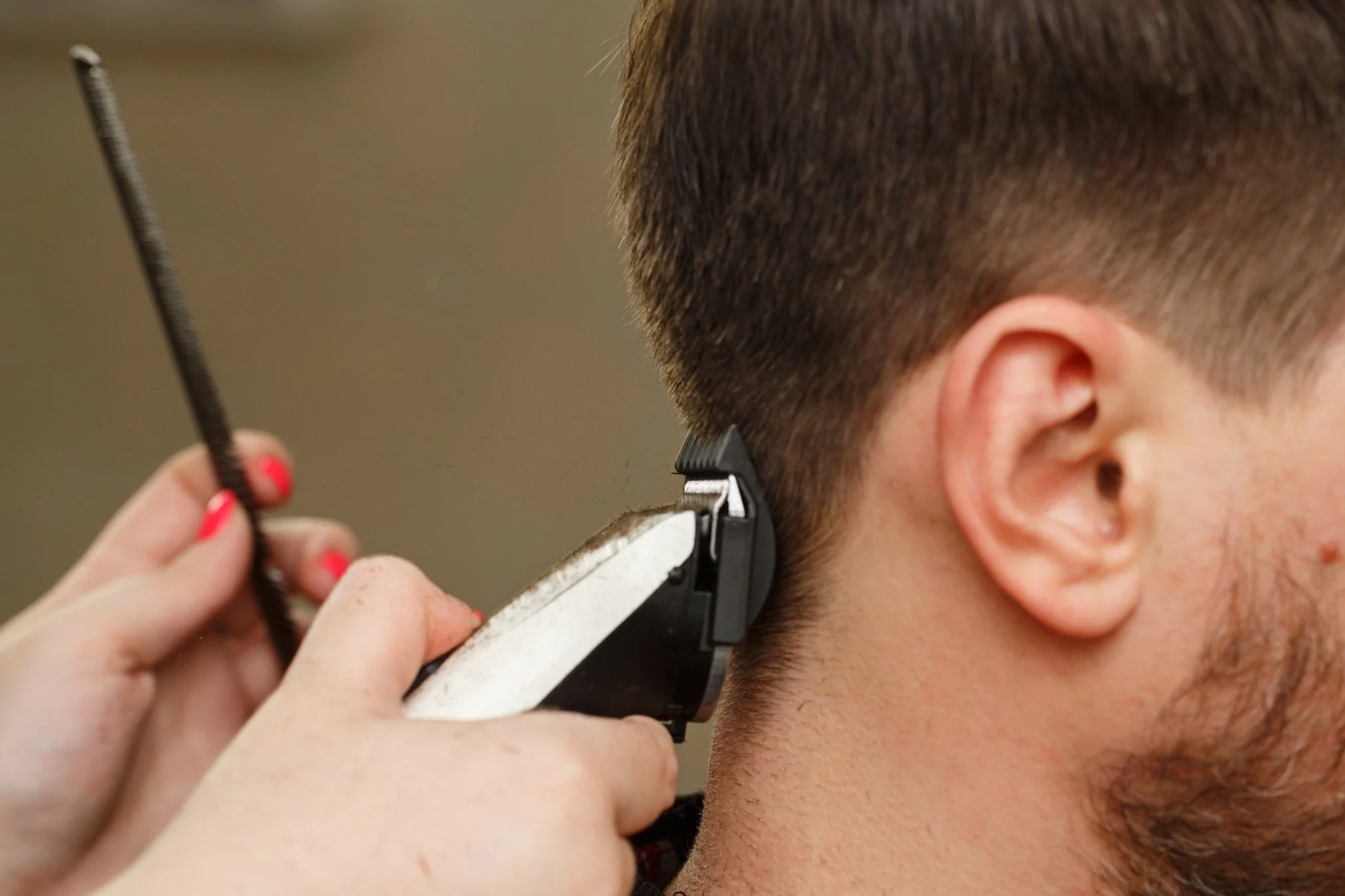Stylist using clippers for a men's designer haircut at Willow's Cove Salon in Mineola, NY