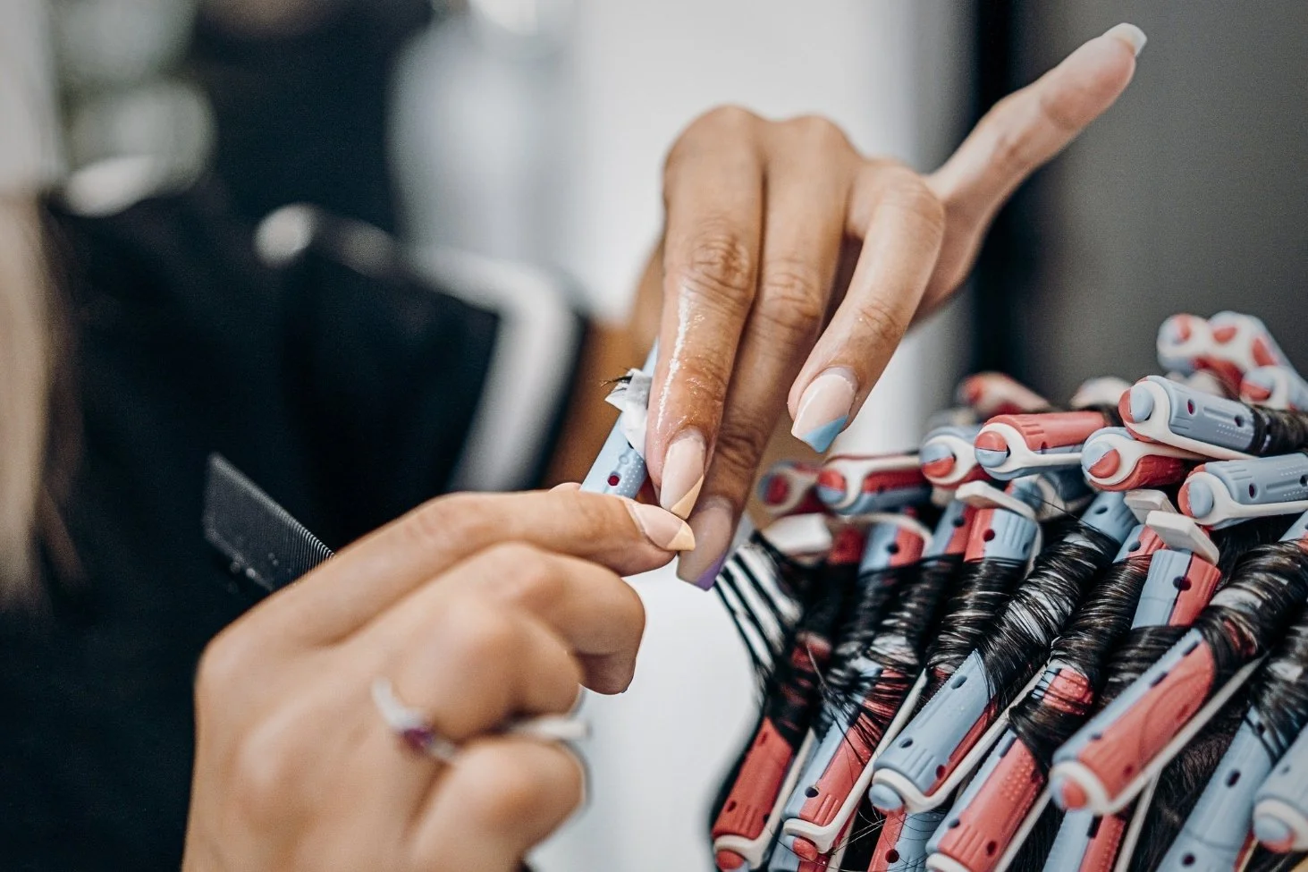 Stylist setting perm rods in a client's hair during a perm service at Willow's Cove Salon