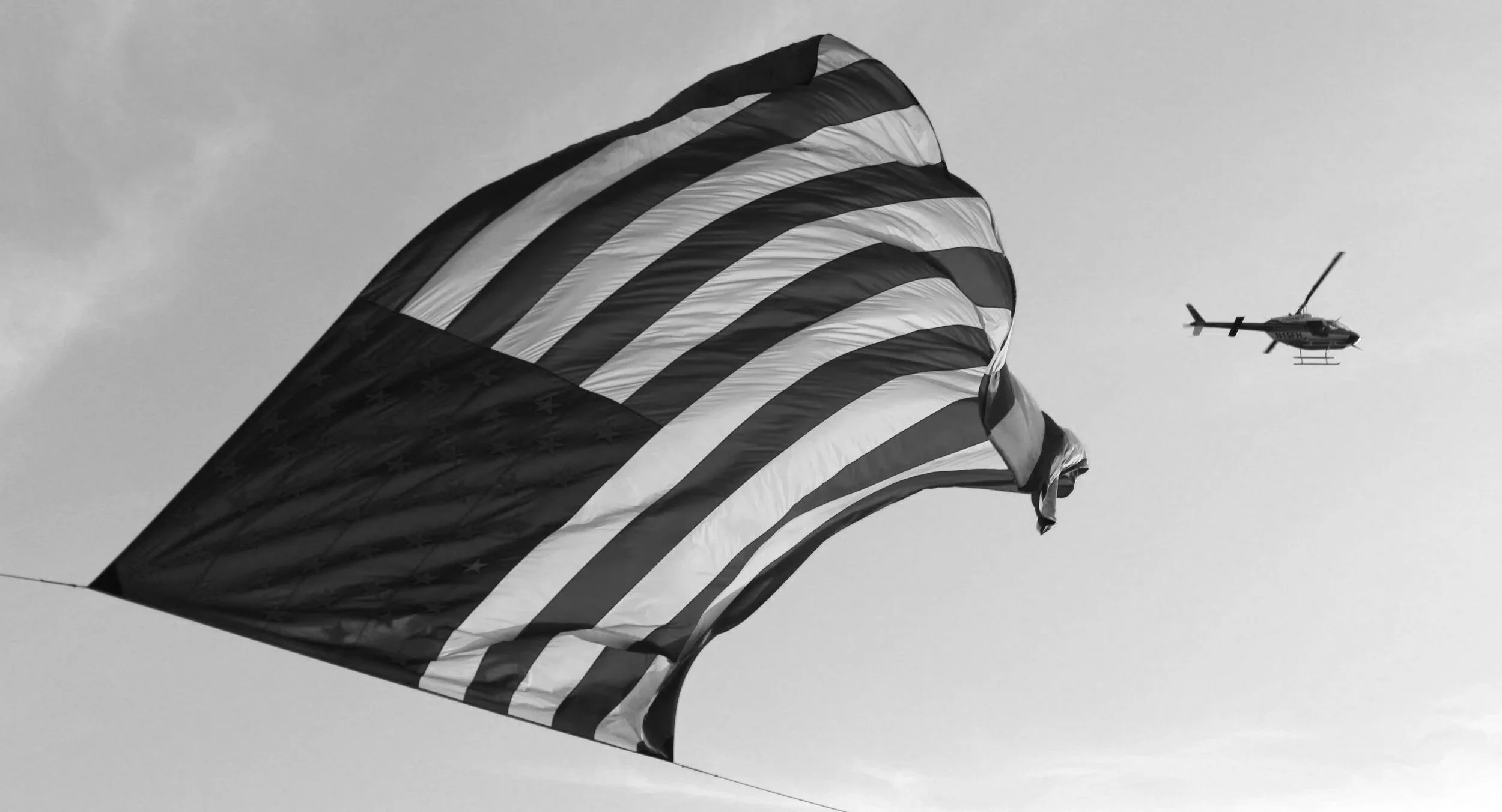 American flag with helicopter in flight