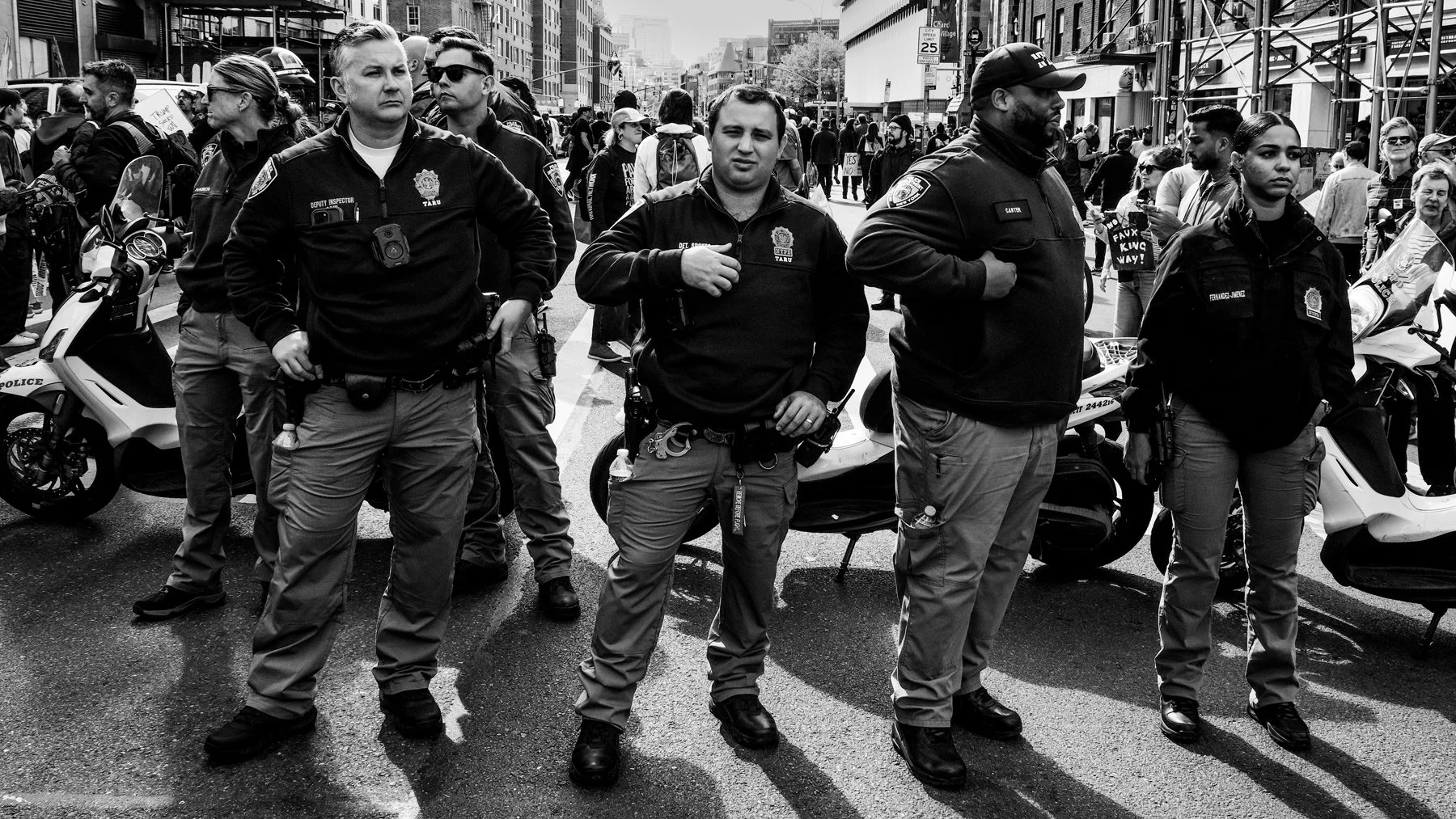 Group of police officers standing in formation on city street during a protest.