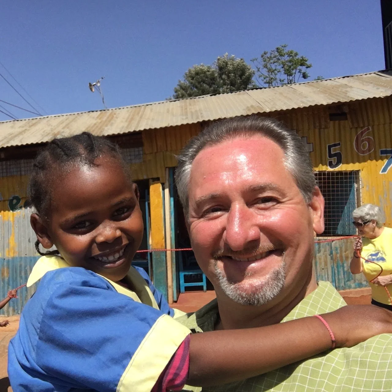 Image of Michael Allen carrying child at Huruma Hope