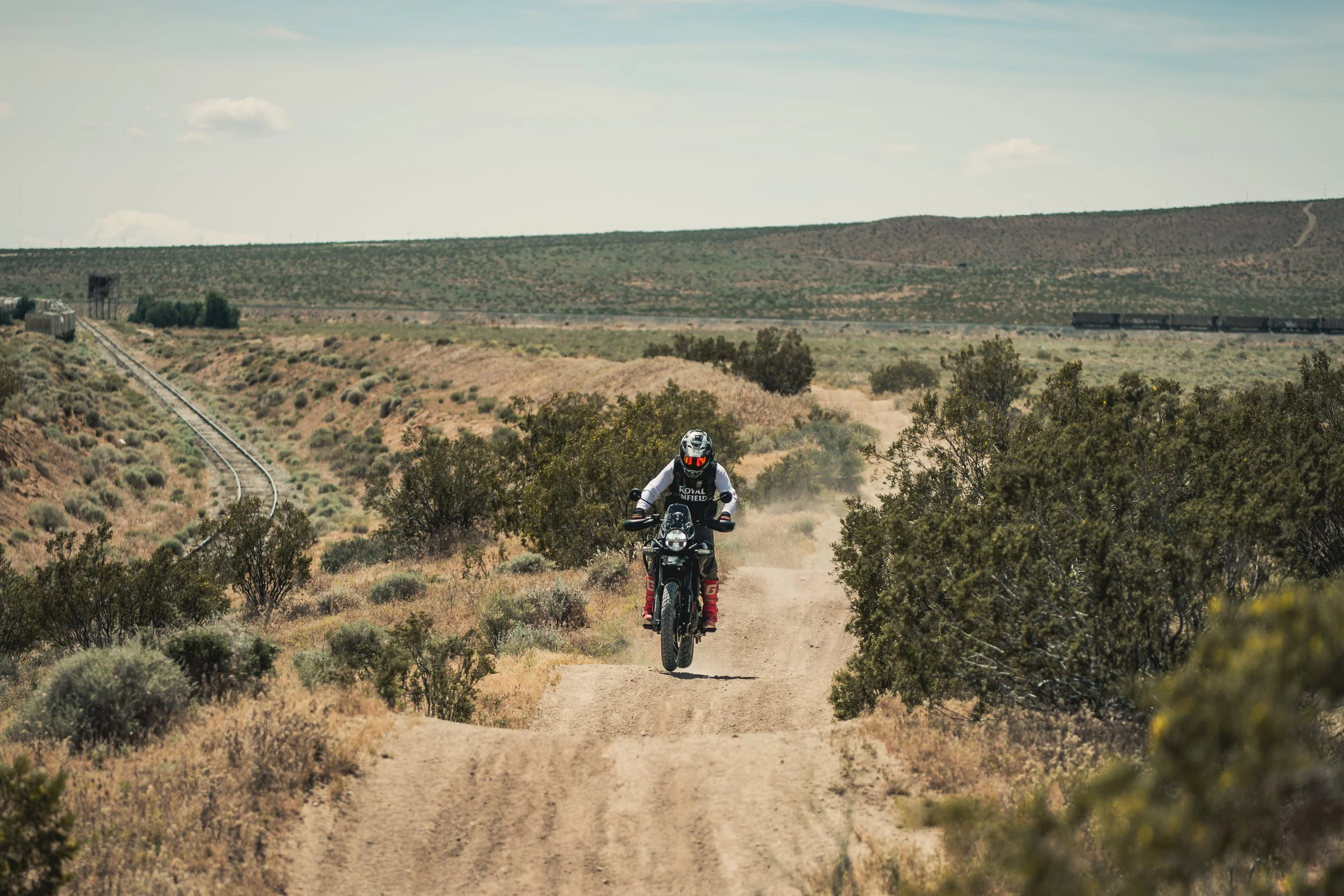 Rider on a Royal Enfield Himalayan 450 coming up a desert dirt trail