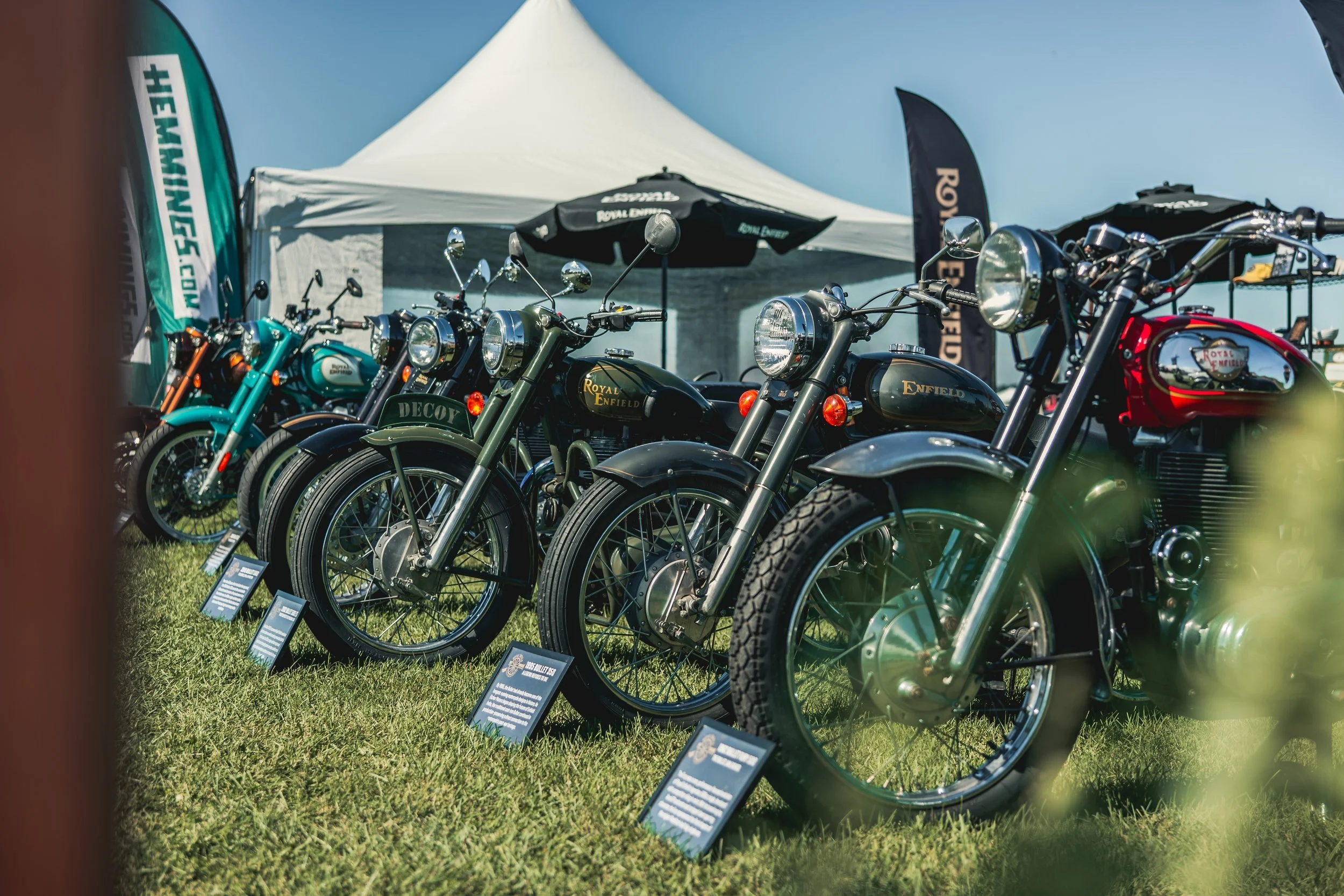 Row of Royal Enfield motorcycles under a tent at the Audrain activation