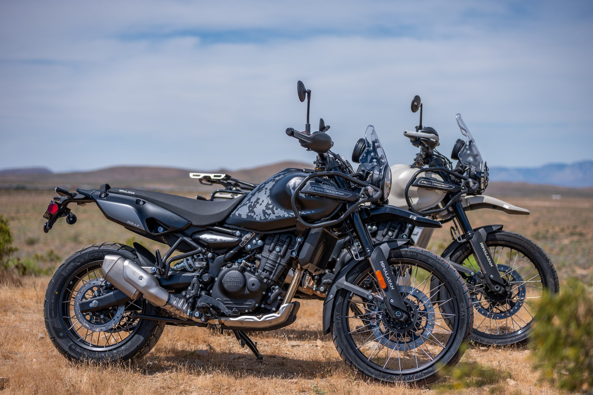 Two Royal Enfield Himalayan 450 Mana Black motorcycles parked in the desert